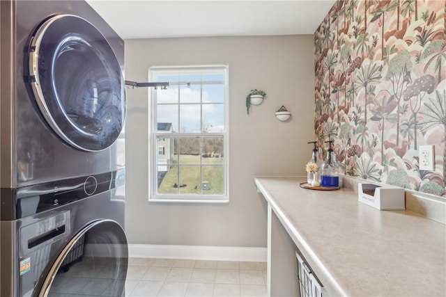 laundry room featuring stacked washer / drying machine, a dry bar, baseboards, and light tile patterned floors