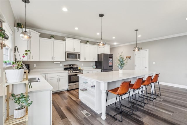 kitchen featuring a center island, light countertops, appliances with stainless steel finishes, dark wood-type flooring, and white cabinets