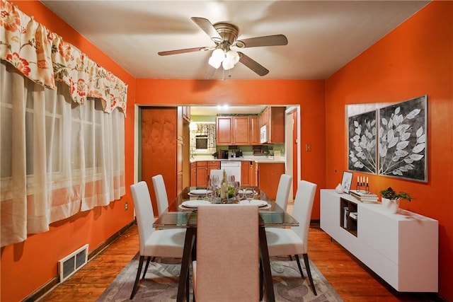 dining area featuring ceiling fan, visible vents, and dark wood finished floors