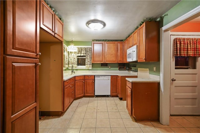 kitchen with white appliances, light tile patterned floors, light countertops, and brown cabinetry