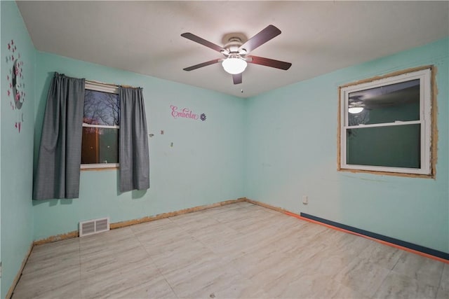 unfurnished room featuring baseboards, visible vents, and ceiling fan