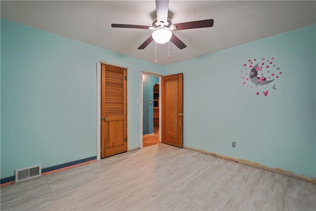 unfurnished room featuring ceiling fan, visible vents, and baseboards