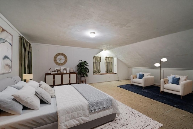 bedroom with a textured ceiling, vaulted ceiling, and carpet flooring