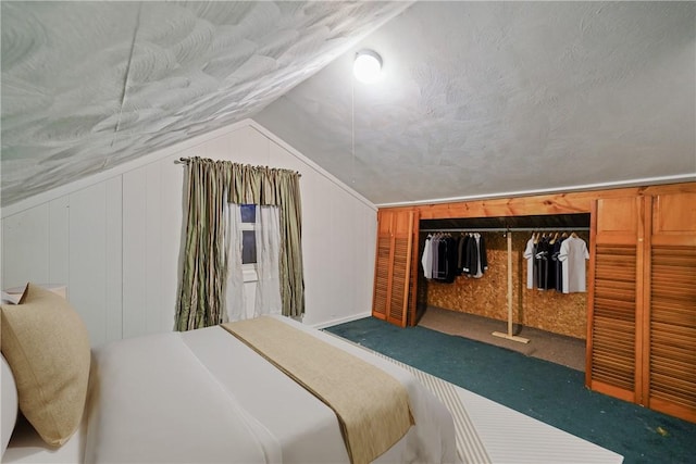 carpeted bedroom with wooden walls, a closet, vaulted ceiling, and a textured ceiling