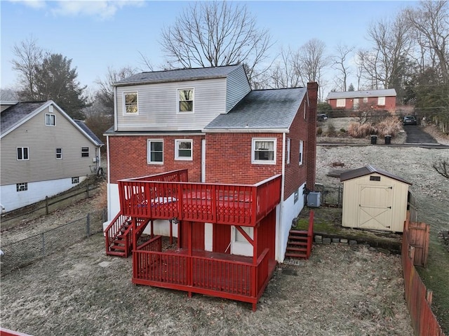 rear view of property with a storage shed, brick siding, stairway, and an outbuilding