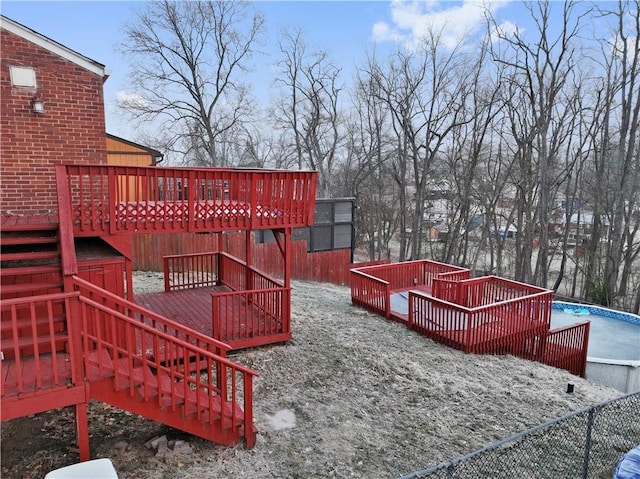 view of yard with stairway, an outdoor pool, fence, and a deck