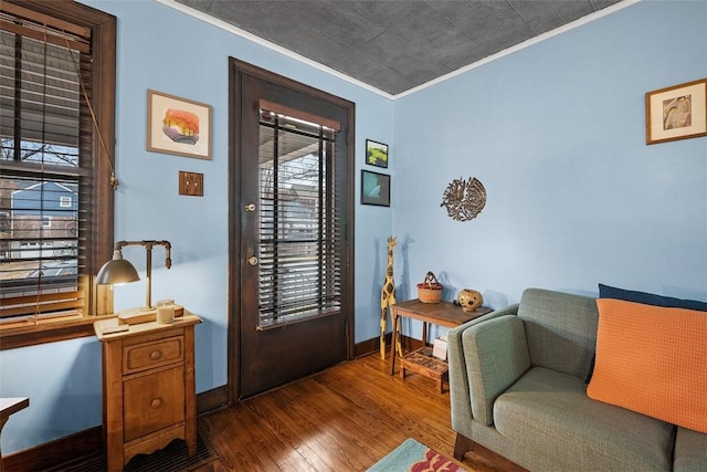 entrance foyer featuring ornamental molding, dark wood-style flooring, and baseboards