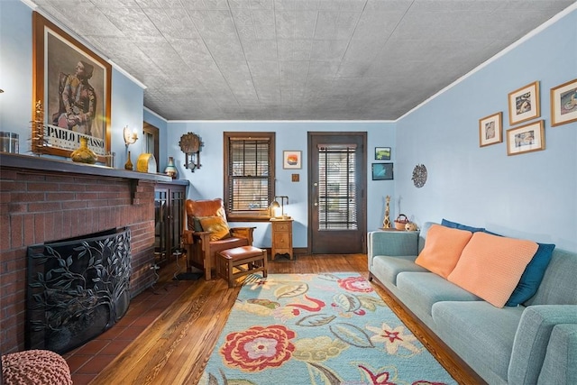 living room featuring a brick fireplace, ornamental molding, and wood finished floors