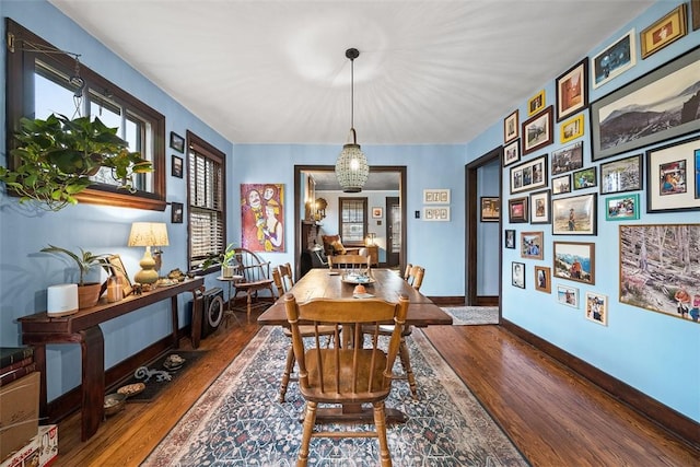 dining area featuring baseboards and wood finished floors