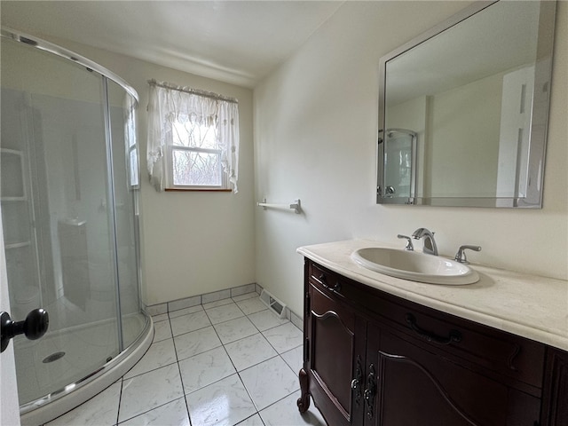 full bath featuring a shower stall, vanity, and baseboards