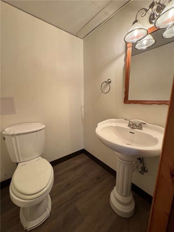 bathroom with wood finished floors, toilet, and baseboards