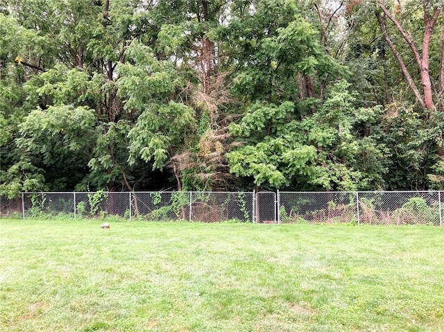 view of yard with fence and a wooded view