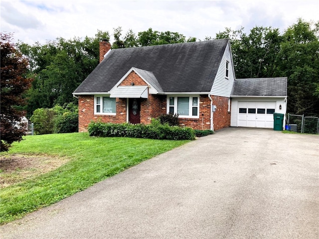 view of front of home with a garage, driveway, brick siding, a chimney, and a front yard