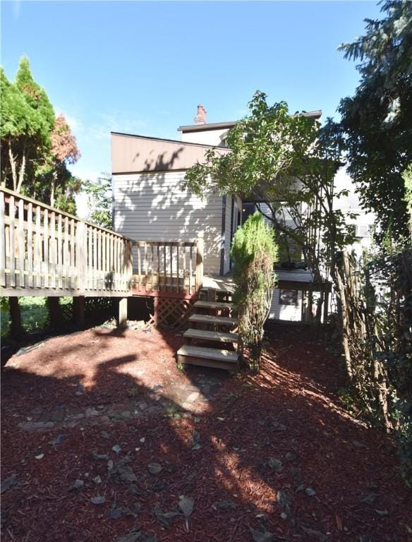 rear view of property featuring a wooden deck