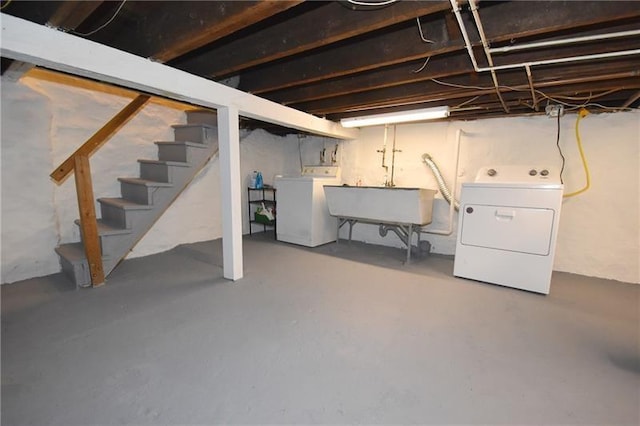 unfinished basement with washer and dryer, a sink, and stairs