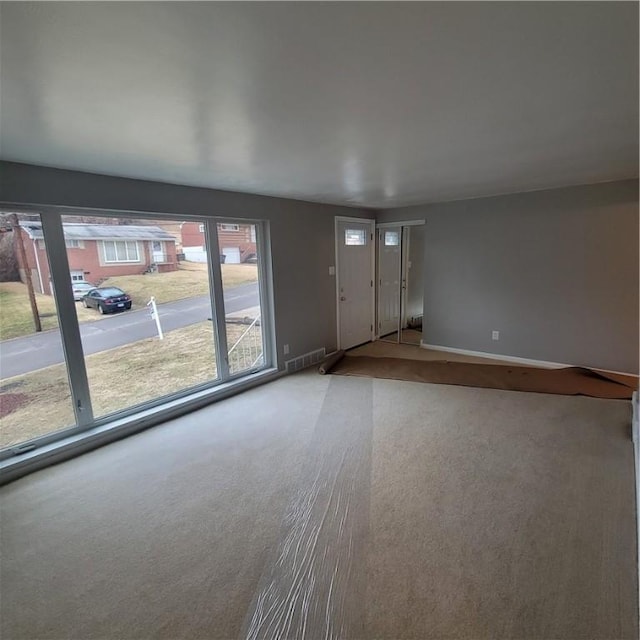 interior space featuring carpet, visible vents, and baseboards