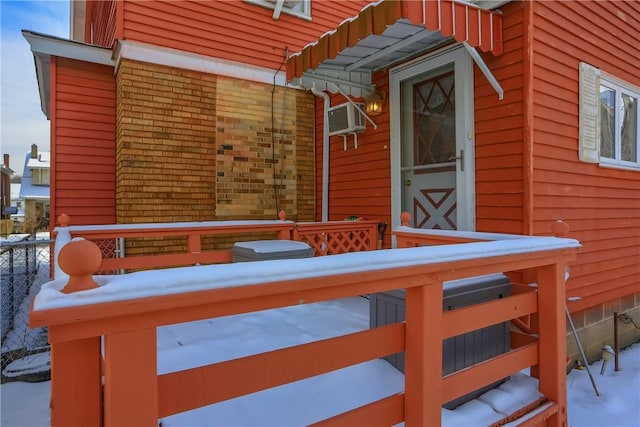 snow covered deck with a wall mounted AC