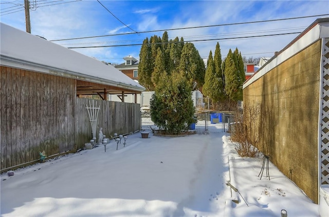 yard covered in snow featuring fence