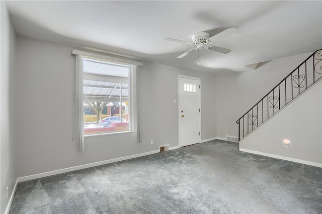 carpeted foyer entrance featuring visible vents, ceiling fan, stairs, and baseboards