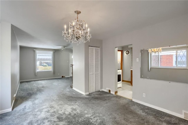 interior space featuring visible vents, baseboards, carpet floors, and a chandelier