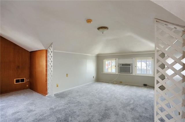 interior space with carpet flooring, cooling unit, visible vents, and vaulted ceiling