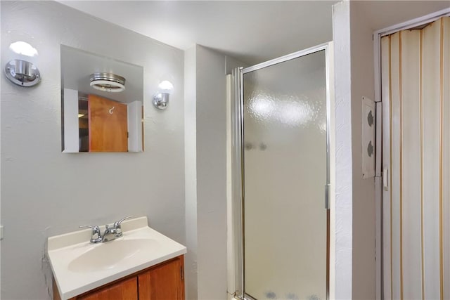 full bath with a stall shower and vanity