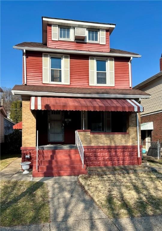 traditional style home with brick siding and covered porch