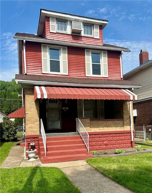american foursquare style home with fence