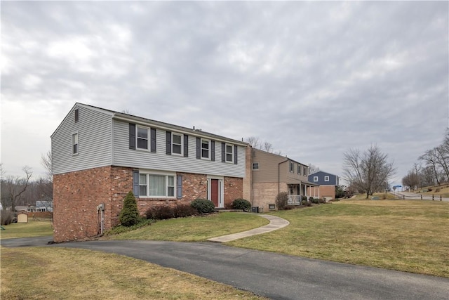 colonial home with a front yard and brick siding