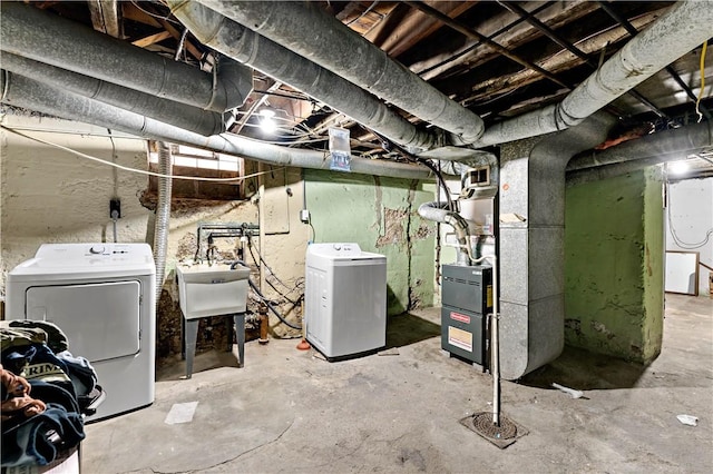 unfinished basement with heating unit, a sink, and independent washer and dryer