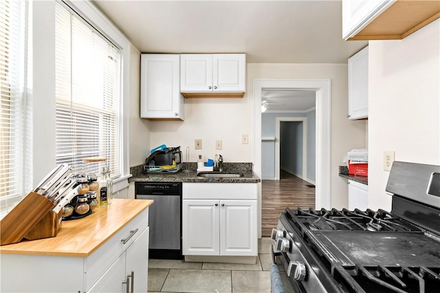 kitchen featuring appliances with stainless steel finishes, a sink, butcher block counters, and white cabinetry