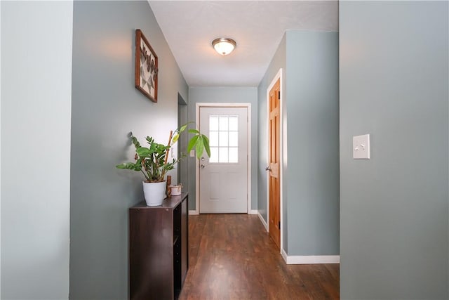 doorway featuring dark wood finished floors and baseboards