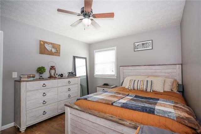 bedroom with baseboards, a textured ceiling, a ceiling fan, and dark wood-type flooring