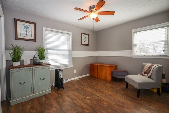 living area featuring dark wood-style floors, baseboards, and a ceiling fan