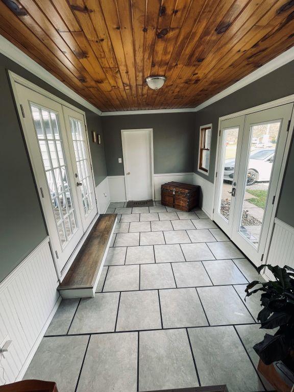 unfurnished sunroom with wooden ceiling and french doors