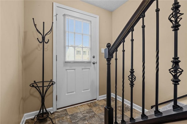 doorway with stone finish flooring, stairs, and baseboards