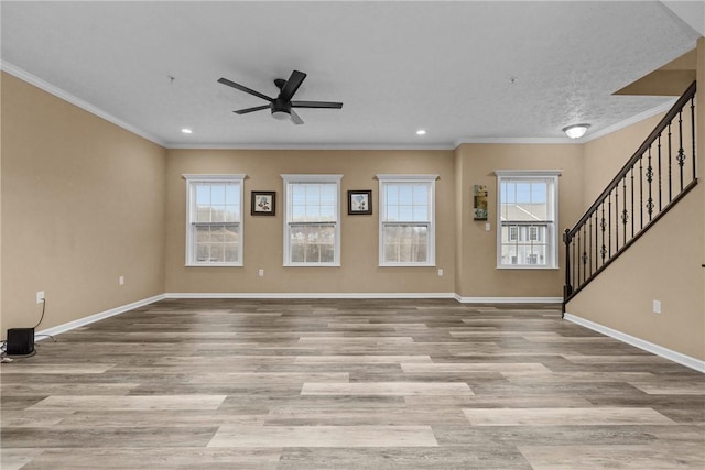 unfurnished living room with a wealth of natural light, baseboards, and wood finished floors