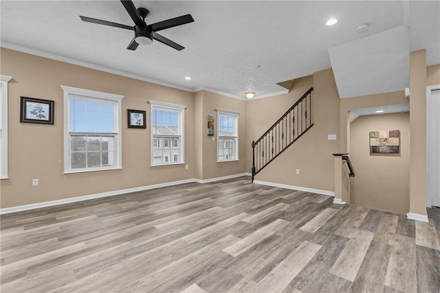 unfurnished living room featuring recessed lighting, baseboards, stairway, light wood-type flooring, and crown molding