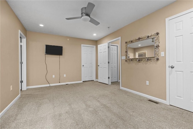 spare room featuring carpet floors, visible vents, and baseboards