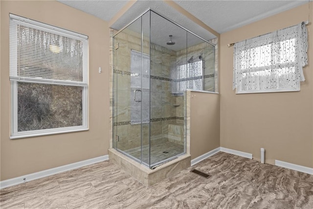 bathroom featuring visible vents, a shower stall, baseboards, and a textured ceiling