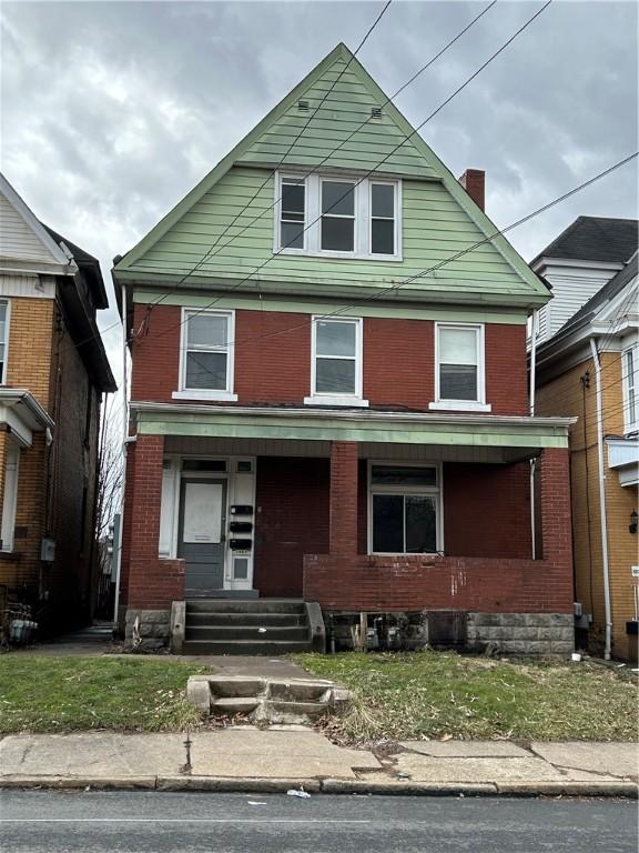 view of front of house featuring covered porch and brick siding