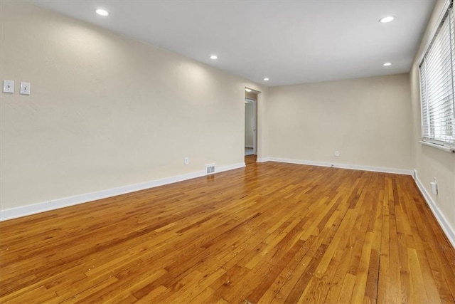 spare room featuring light wood-style flooring, visible vents, baseboards, and recessed lighting