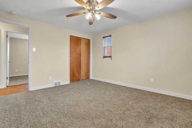 unfurnished bedroom with carpet, a closet, visible vents, a ceiling fan, and baseboards