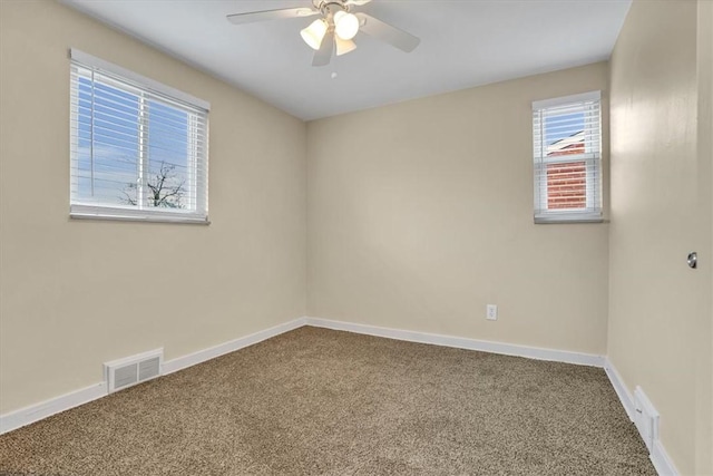 unfurnished room with carpet floors, baseboards, and visible vents