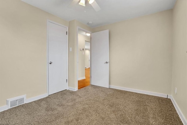 unfurnished bedroom featuring carpet, visible vents, ceiling fan, and baseboards