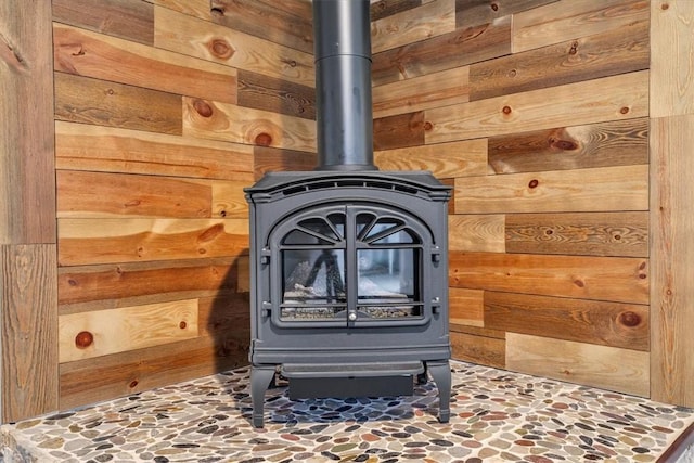 details featuring a wood stove and wood walls