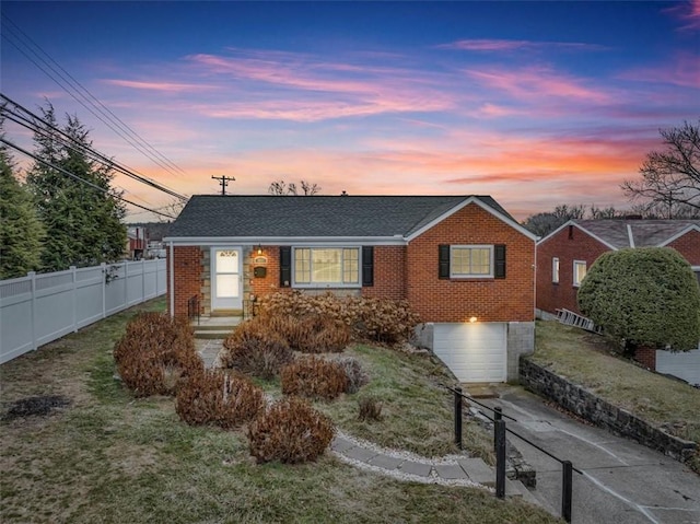 view of front of home with driveway, a shingled roof, an attached garage, fence, and brick siding