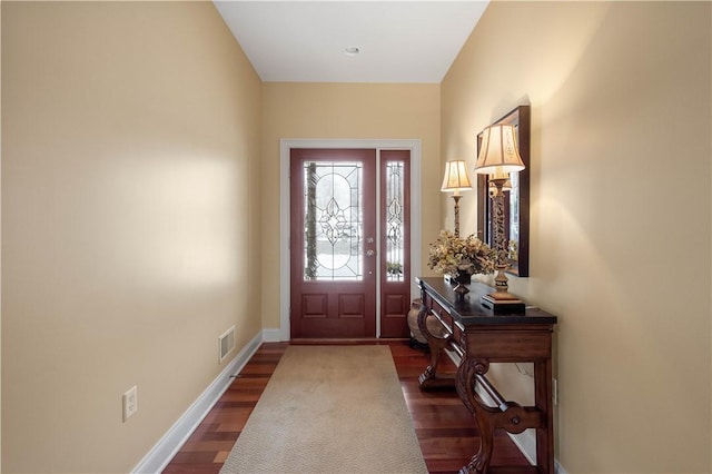 entrance foyer featuring baseboards, visible vents, and dark wood-style flooring