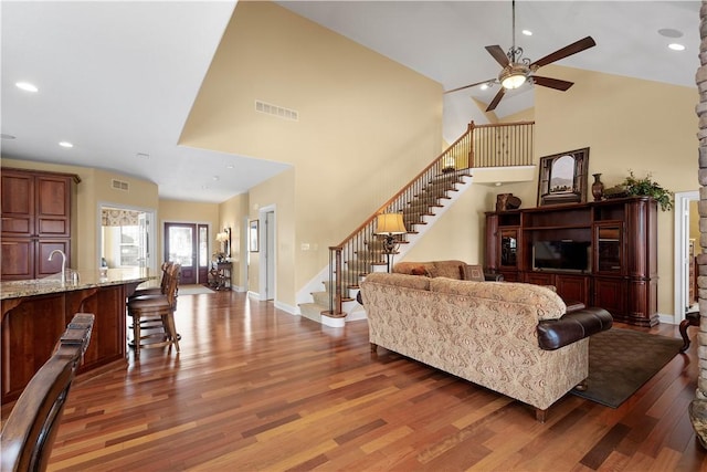 living area with stairs, visible vents, wood finished floors, and recessed lighting