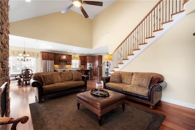 living area featuring dark wood-type flooring, visible vents, stairway, and baseboards